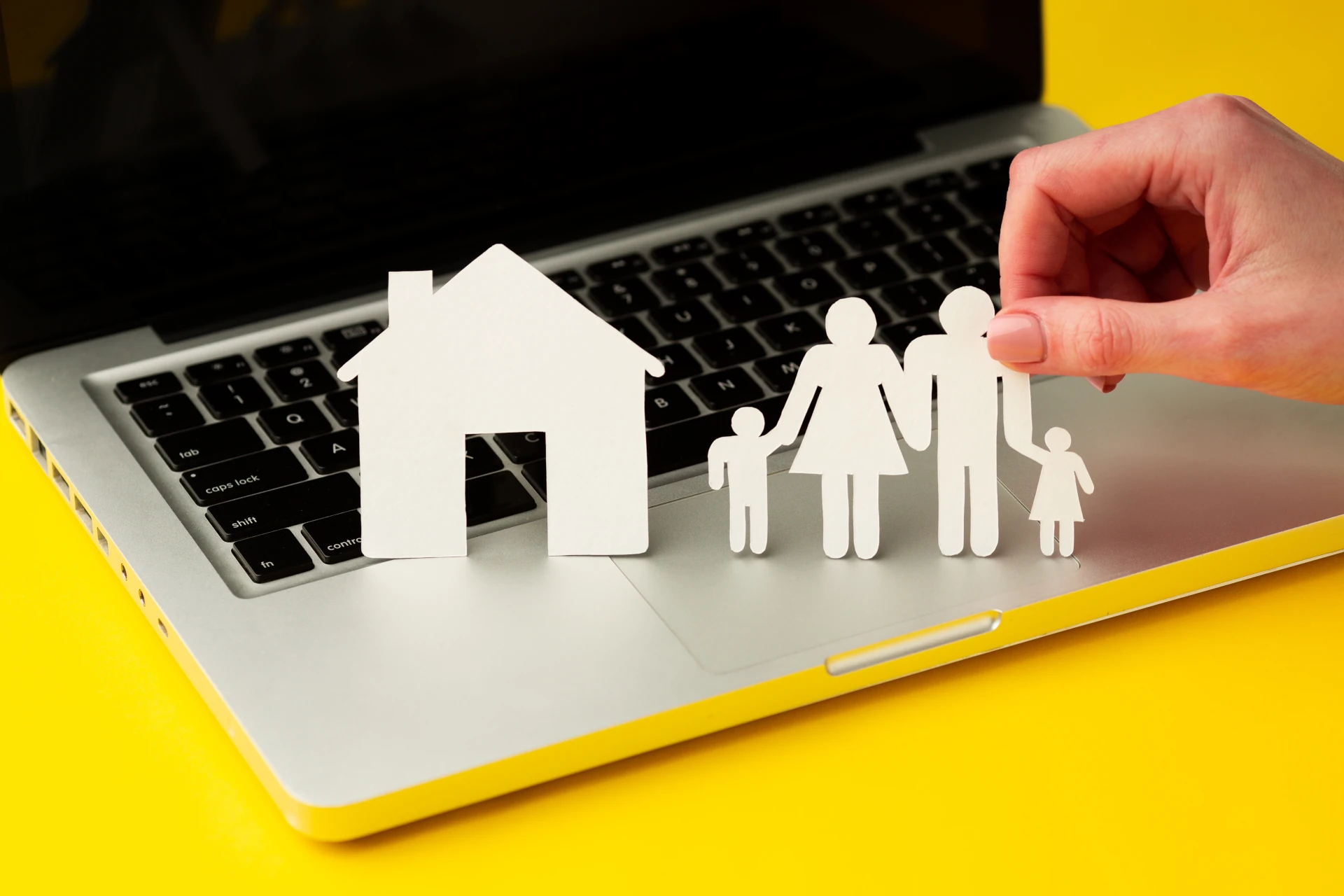 Concetto di ereditarietà in C# rappresentato da una famiglia e una casa di carta su un laptop.